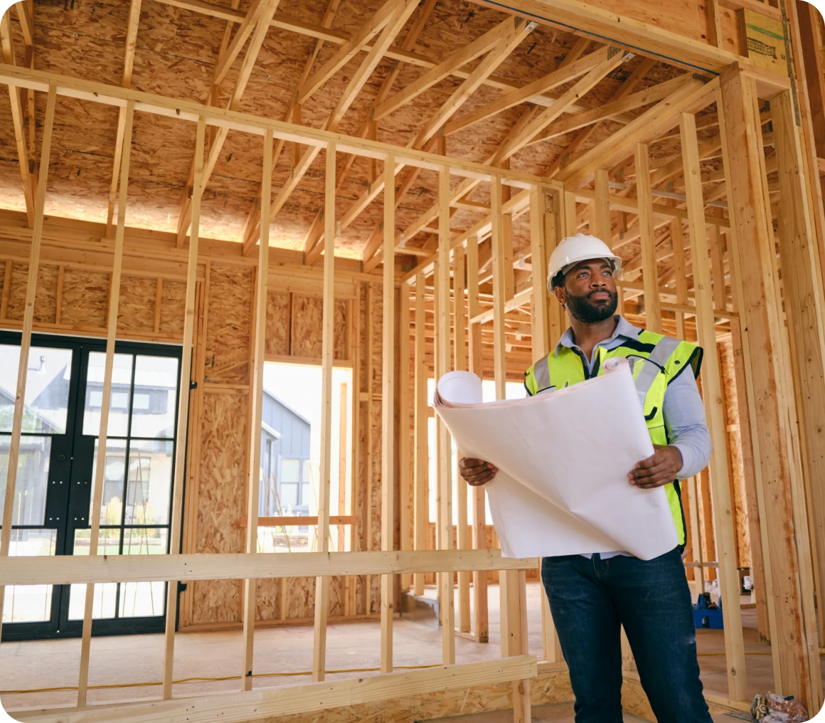 Engineer with blueprints at construction site
