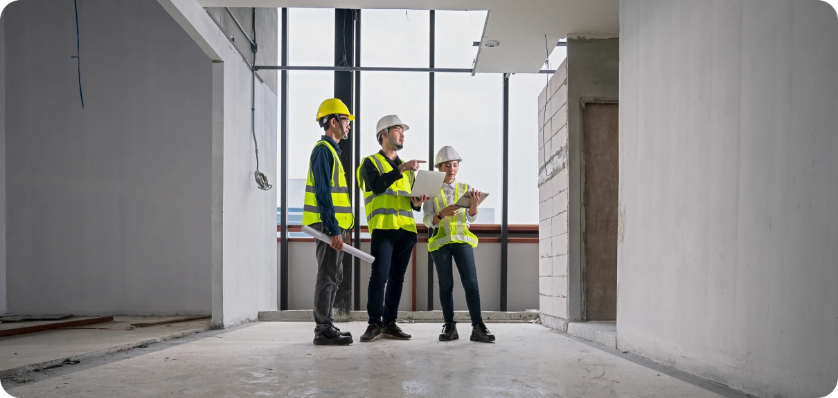 Architects discussing project in unfinished room.