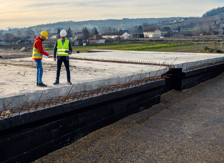 Two engineers examining unfinished bridge structure